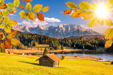  idyllic landscape with mountain range, lake and cottage at autumn