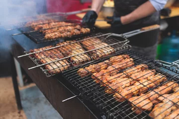 Foto op Aluminium Food festival with food stall kiosk, open-air outdoor fair market, assortment of different traditional European grilled barbecued street food with sausages, bbq, chicken, pork and lamb on a large pan © tsuguliev