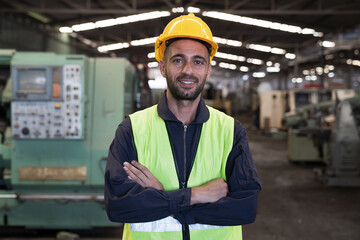 Portrait of male engineer worker working and standing with crossed arms in factory. Mature male...