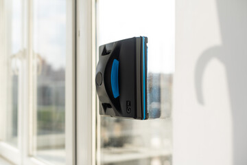 Modern window washer robot performs work on a dirty window. Cleaning the house with smart devices....