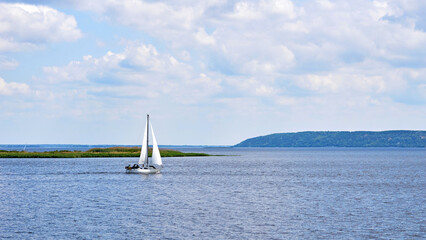 Sailing boat yacht on the river blue expanse on a sunny day