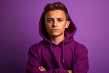 Medium shot portrait photography of a beautiful boy in his 30s wearing a stylish hoodie against a vibrant purple background. With generative AI technology