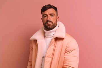 Obraz premium Medium shot portrait photography of a satisfied boy in his 30s wearing a cozy winter coat against a peachy pink background. With generative AI technology