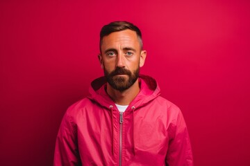 Fototapeta premium Lifestyle portrait photography of a glad boy in his 30s wearing a lightweight windbreaker against a hot pink background. With generative AI technology