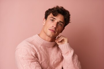Fototapeta premium Medium shot portrait photography of a satisfied boy in his 20s wearing a cozy sweater against a dusty rose background. With generative AI technology