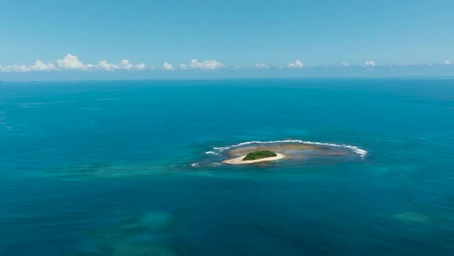 Beautiful Jobo Island surrounded by white sand. Blue sea under blue sky. Mindanao, Philippines.