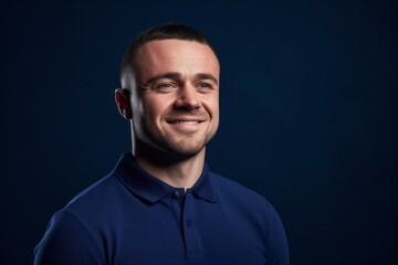 Fototapeta premium Close-up portrait photography of a satisfied boy in his 30s wearing a sporty polo shirt against a navy blue background. With generative AI technology