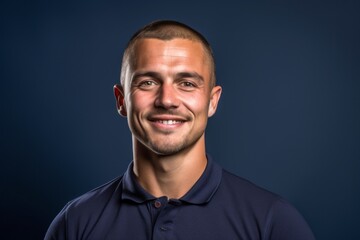Fototapeta premium Close-up portrait photography of a satisfied boy in his 30s wearing a sporty polo shirt against a navy blue background. With generative AI technology
