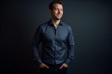 Obraz premium Lifestyle portrait photography of a glad boy in his 30s wearing an elegant long-sleeve shirt against a matte black background. With generative AI technology