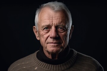 Obraz premium Close-up portrait photography of a glad old man wearing a cozy sweater against a matte black background. With generative AI technology