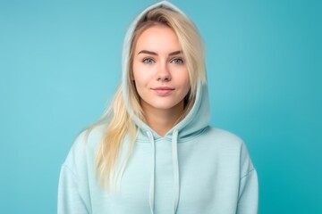 Obraz premium Medium shot portrait photography of a beautiful girl in her 30s wearing a comfortable hoodie against a soft blue background. With generative AI technology
