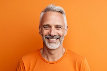 Obraz premium Medium shot portrait photography of a joyful mature man wearing a casual t-shirt against a tangerine orange background. With generative AI technology