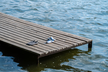 The shoes stand on a wooden pier in the water of the lake.