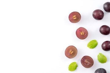 Delicious bunch of grapes fruit spilled over white table background.
