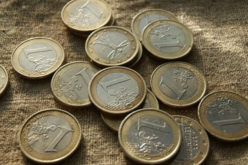European money. Poured 1 Euro coins on natural linen fabric.