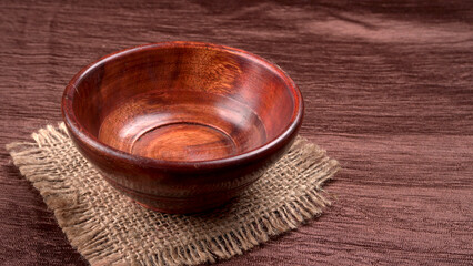Obraz na płótnie Canvas Empty wooden bowl and wooden spoon isolated with copy space.