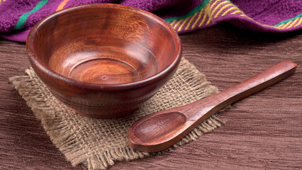 Empty wooden bowl and wooden spoon isolated with copy space.