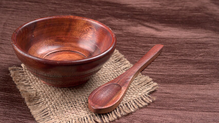 Empty wooden bowl and wooden spoon isolated with copy space.