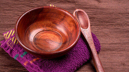 Empty wooden bowl and wooden spoon isolated with copy space.