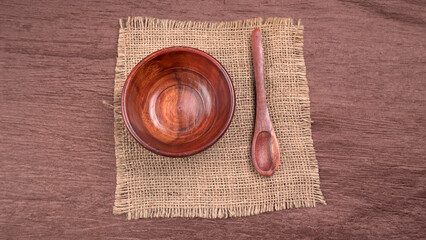Empty wooden bowl and wooden spoon isolated with copy space.