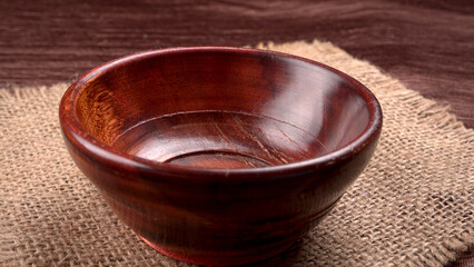 Empty wooden bowl and wooden spoon isolated with copy space.