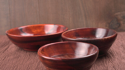 Empty wooden bowl and wooden spoon isolated with copy space.