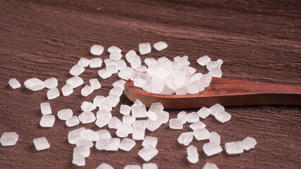 Wooden Spoon with white sugar on the dark background.