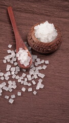 Wooden Spoon with white sugar on the dark background.