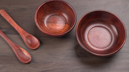 Empty wooden bowl and wooden spoon isolated with copy space.