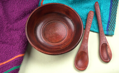 Empty wooden bowl and wooden spoon isolated with copy space