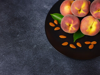 Harvest of peaches for food or juice. fresh organic fruit, vegan food. Large peaches on dark table background, selective focus.