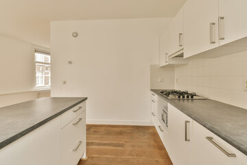 a kitchen with white cupboards and black counter tops on the counters in this photo is taken from the inside