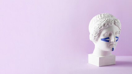 Blue tapes for the face on the bust on a purple background. Non-surgical facelift, rejuvenation....
