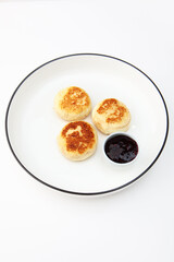 Cottage cheese pancakes or cheesecakes are served with jam. Healthy and delicious breakfast. Copy space. Isolated objects. White background.Vertical photo.