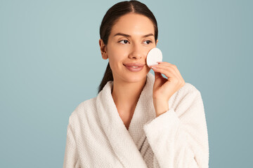 Sensual woman in bathrobe with cotton pad