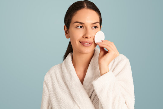 Sensual woman in bathrobe with cotton pad