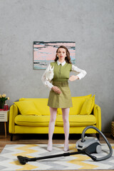 housework concept, young woman with wavy hair standing on clean carpet near vacuum cleaner and yellow couch, gesturing and looking at camera, housewife in dress, domestic life, posing like a doll