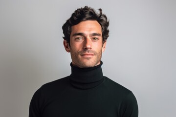 Obraz premium Environmental portrait photography of a glad boy in his 30s wearing a classic turtleneck sweater against a pearl white background. With generative AI technology
