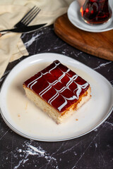 Trilece dessert with milk and caramel. Slice of caramel cake on dark background