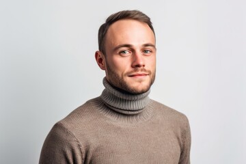 Obraz premium Environmental portrait photography of a glad boy in his 30s wearing a classic turtleneck sweater against a pearl white background. With generative AI technology
