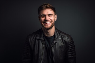 Medium shot portrait photography of a grinning boy in his 30s wearing a trendy leather jacket against a cool gray background. With generative AI technology