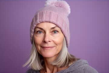 Medium shot portrait photography of a tender mature woman wearing a warm beanie or knit hat against a lilac purple background. With generative AI technology