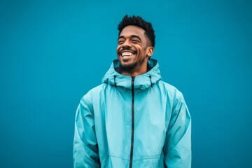 Fototapeta premium Lifestyle portrait photography of a satisfied boy in his 30s wearing a lightweight windbreaker against a cerulean blue background. With generative AI technology