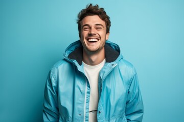 Fototapeta premium Lifestyle portrait photography of a satisfied boy in his 30s wearing a lightweight windbreaker against a cerulean blue background. With generative AI technology