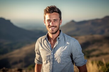 Fototapeta na wymiar Eclectic portrait photography of a satisfied boy in his 30s wearing a casual short-sleeve shirt against a mountain range background. With generative AI technology