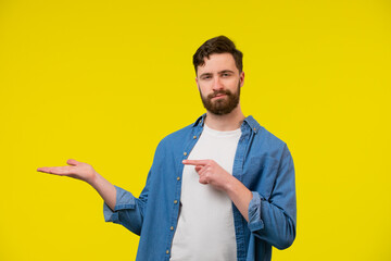 Man looking at the camera with open palm and pointing his finger at it