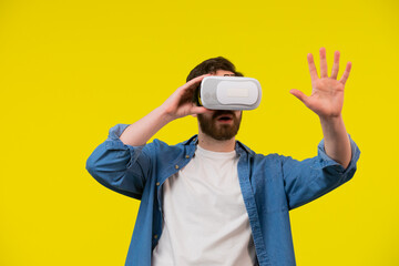 Man wears a virtual reality glasses and looking at his hand through it