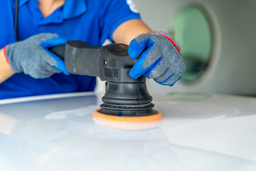 Close up hands of a man using an electric car wax polisher to wax car's roof
