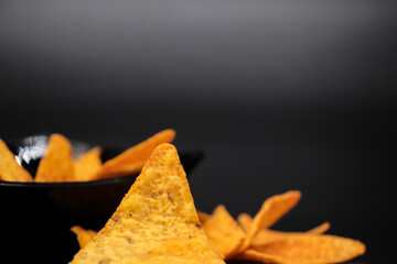 Naklejka premium mexican nachos in a bowl on black background with copy space