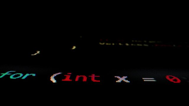 Closeup macro shot movement of coding script moving across LED screen with real-time AI-generated typing, showcasing advanced AI learning in optimization, debug and coding for software development.
